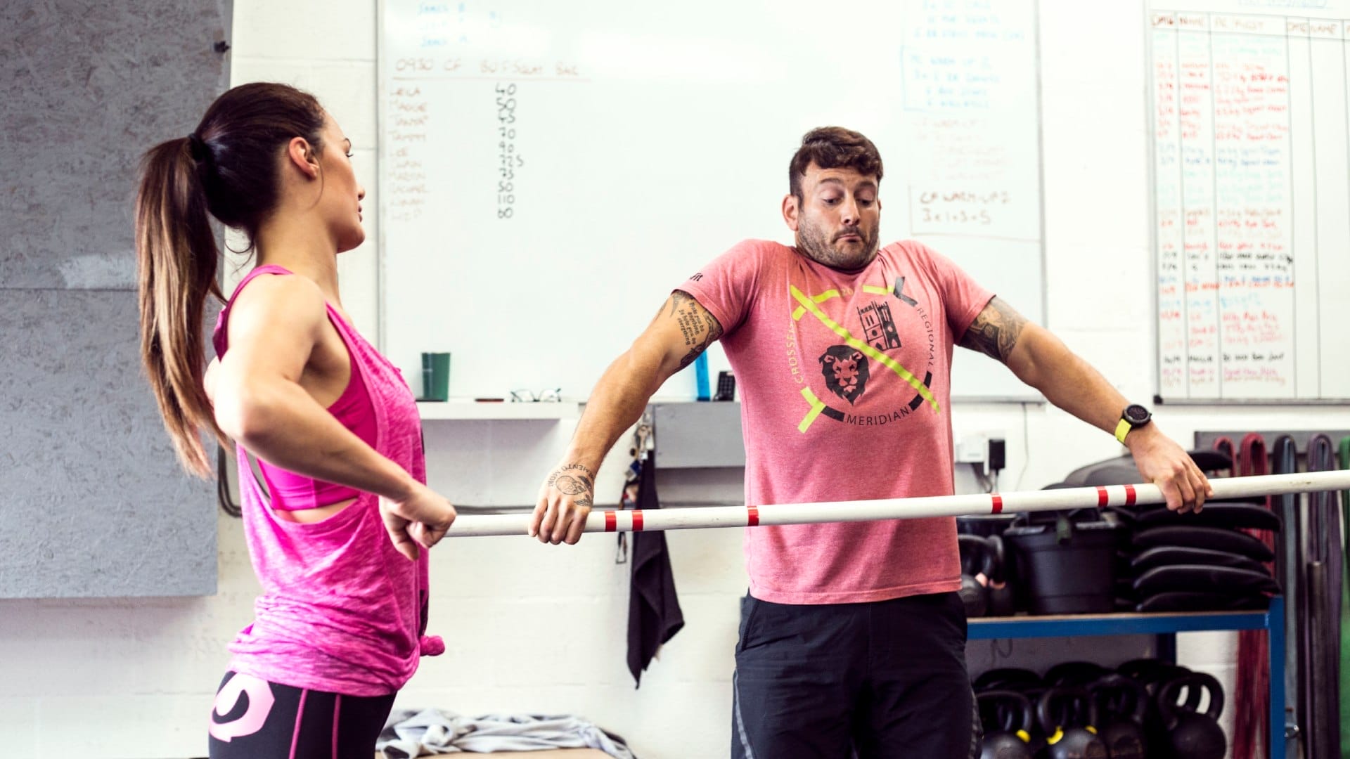 A coach demonstrating extension in the snatch to a client